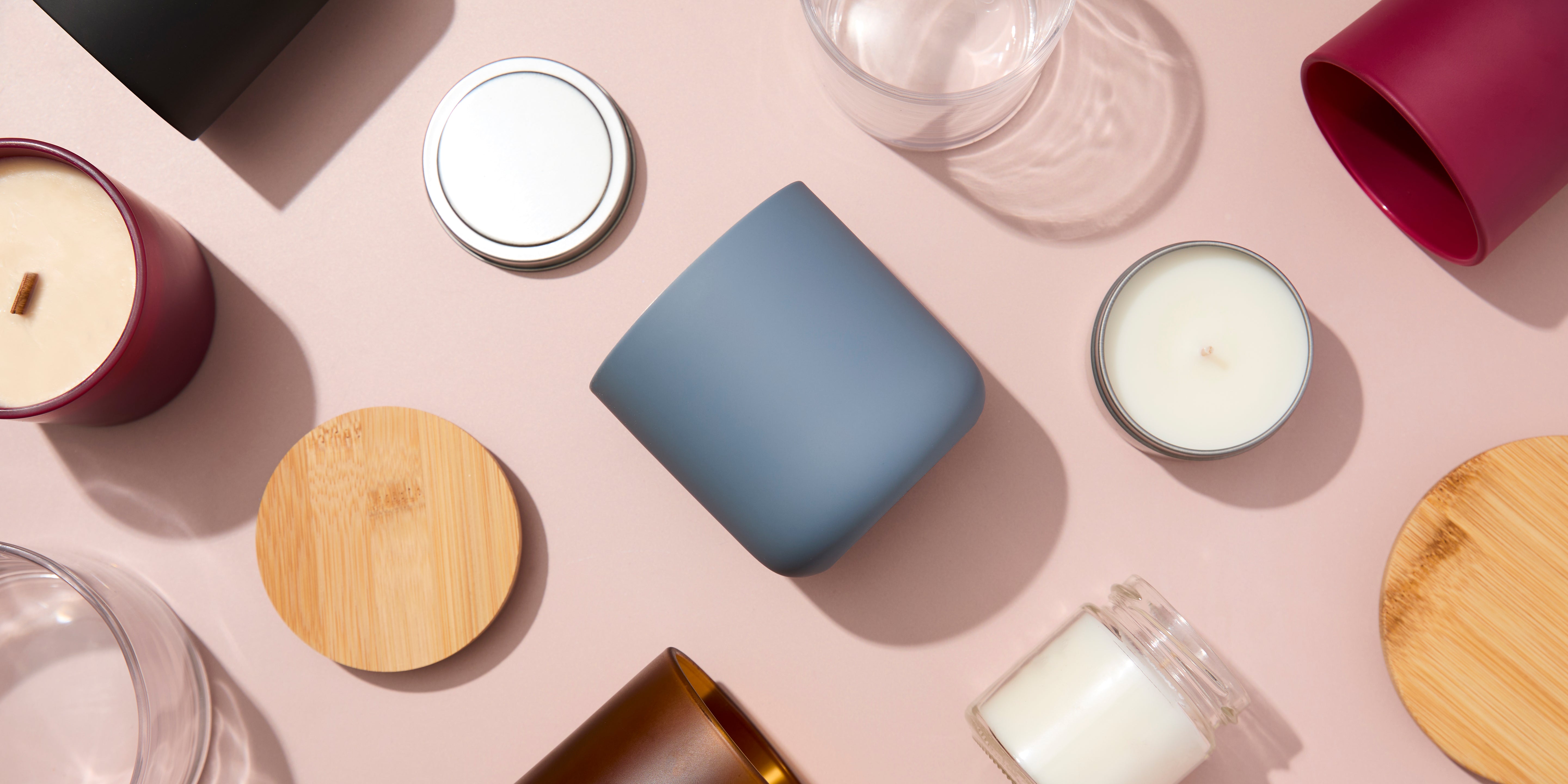 Collection of candles and containers on a peach surface